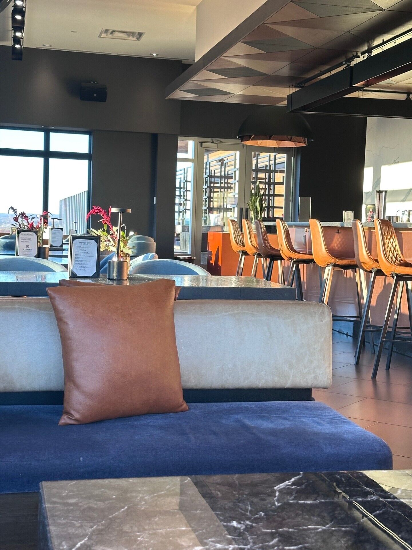 A modern interior with a seating area, a bar, and large windows.