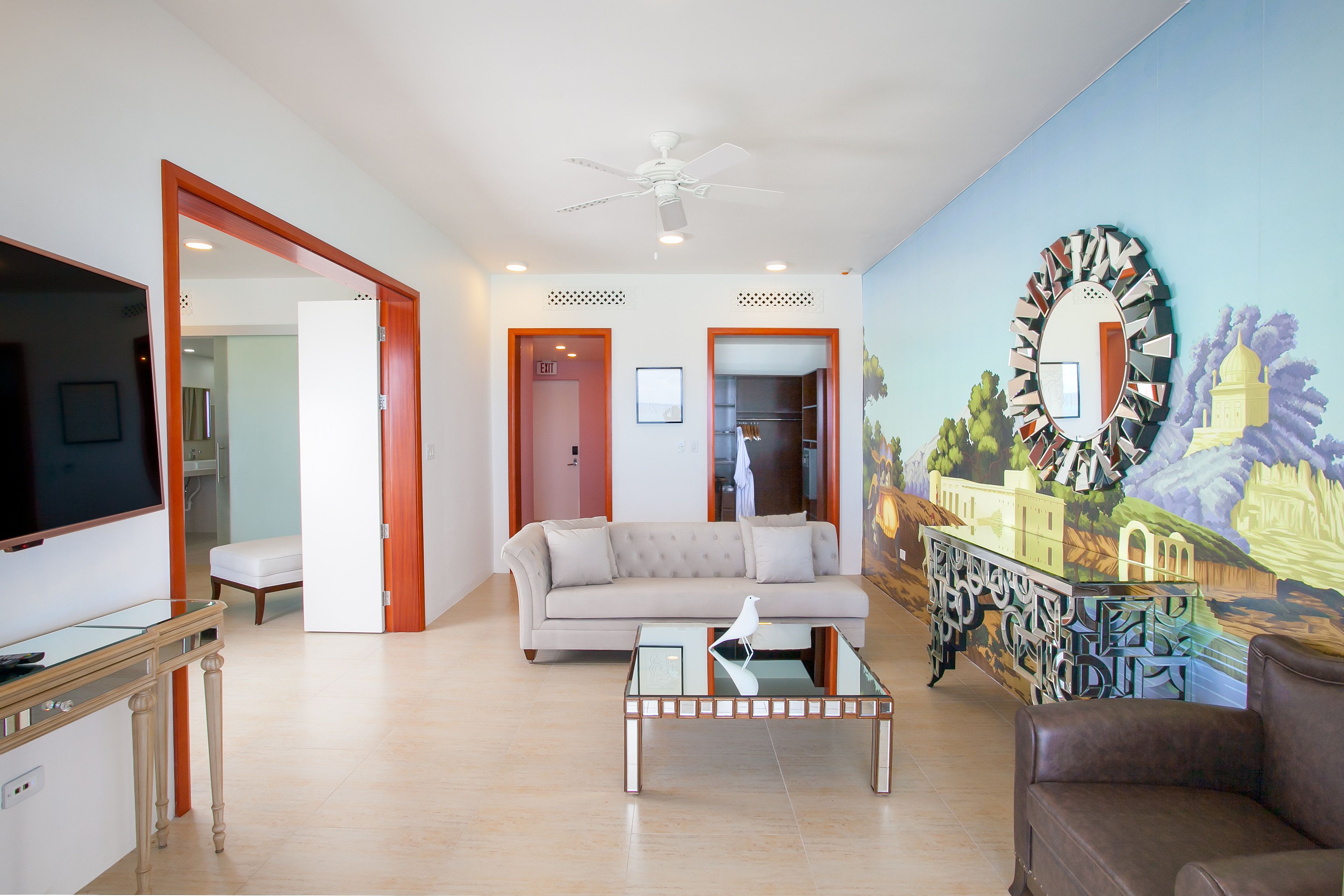 A living room with a sofa, coffee table, and a painting on the wall.