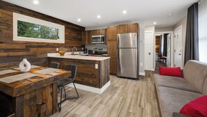 Una cocina moderna con detalles de madera, electrodomésticos de acero inoxidable y una isla central.