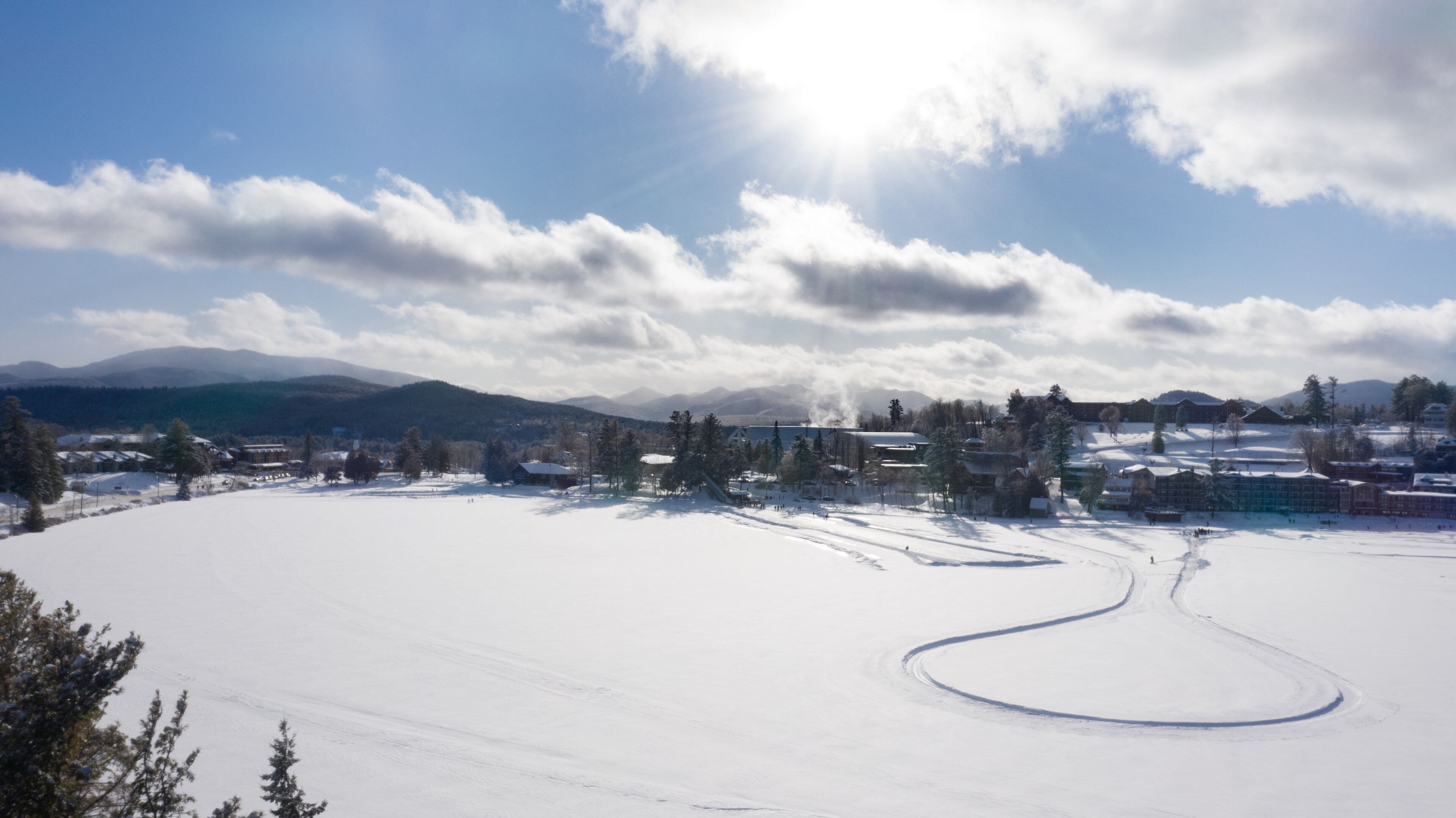 A snow-covered landscape with buildings and trees.