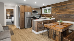 Una cocina moderna con armarios de madera, electrodomésticos de acero inoxidable y una isla central con asientos.
