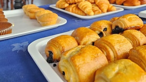 Ein Buffet mit verschiedenen Backwaren, darunter Muffins und Croissants.