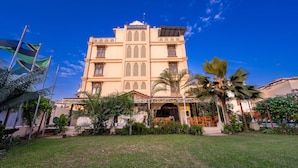 Ein Hotel mit Innenhof, Palmen und blauem Himmel.