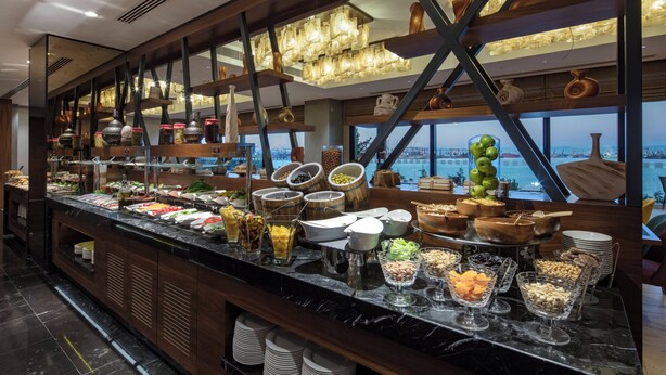 Un bufé con diversas opciones de comida y vista al mar.