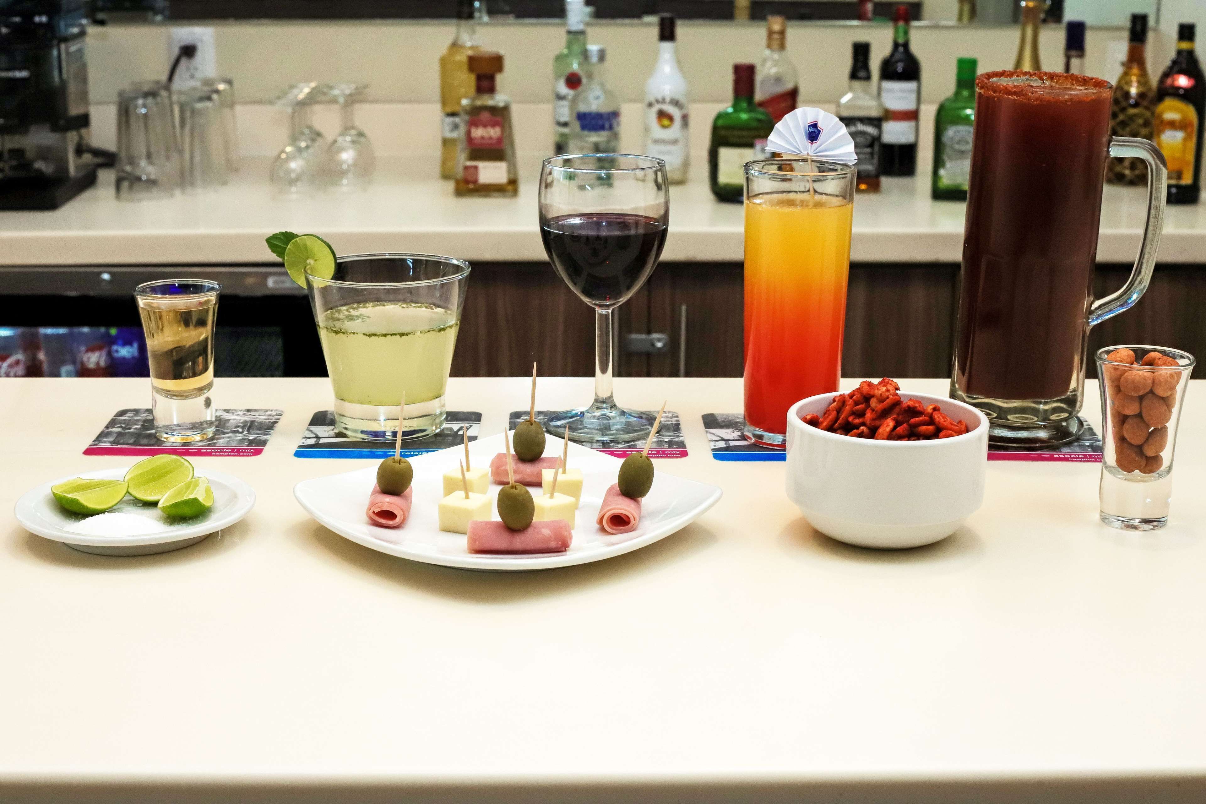 A bar area with various drinks, snacks, and a selection of liquor bottles.
