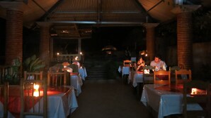 Un comedor interior con mesas cubiertas de manteles blancos, dispuestas en filas.