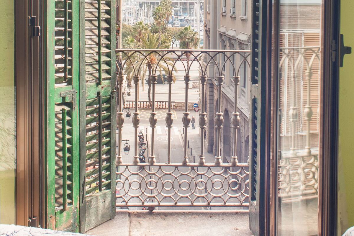 Ein Balkon mit Metallgeländer, Blick auf Gebäude und einen klaren Himmel.