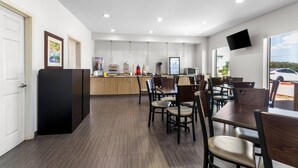Un moderno vestíbulo de hotel con una recepción, zona de estar y un amplio ventanal que ofrece vistas al exterior.