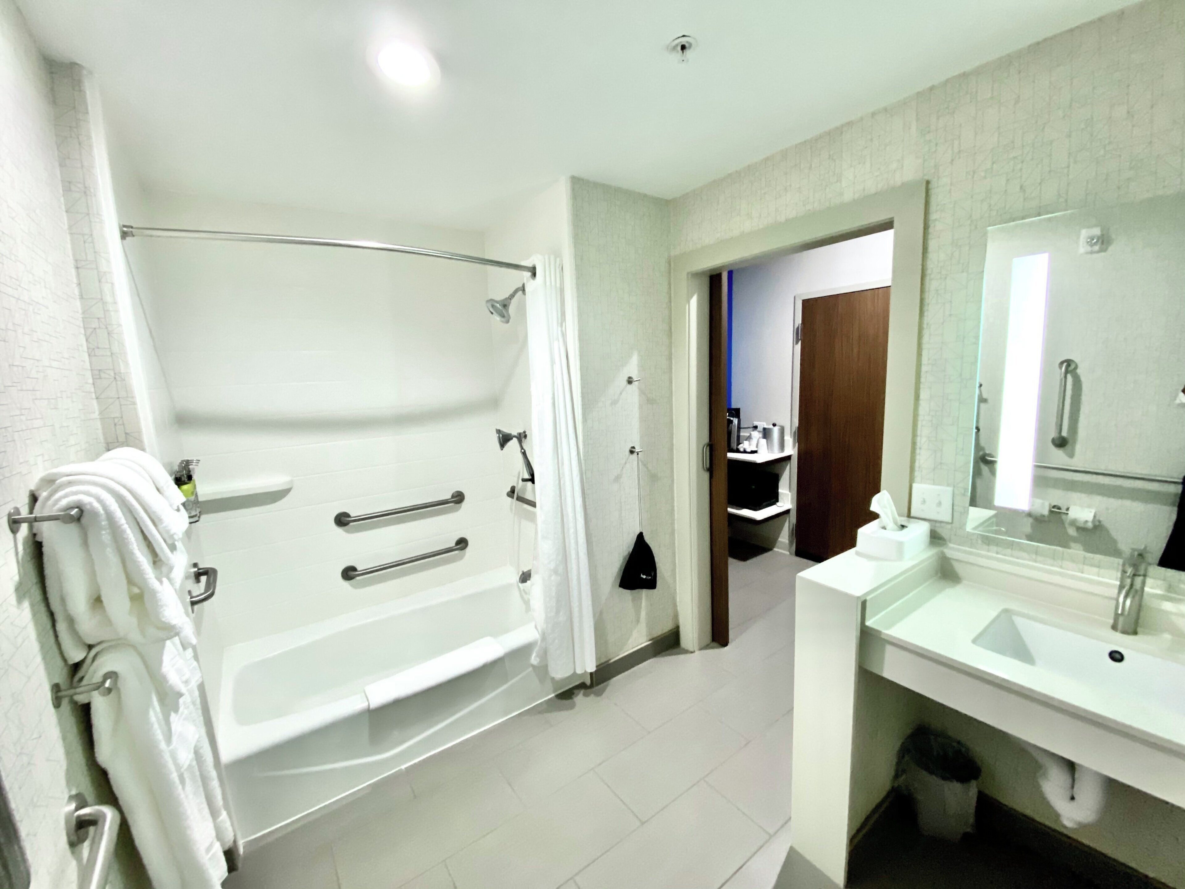 Un baño moderno con una bañera, un lavabo y un espejo.