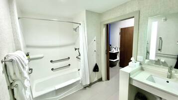 Un baño moderno con una bañera, un lavabo y un espejo.