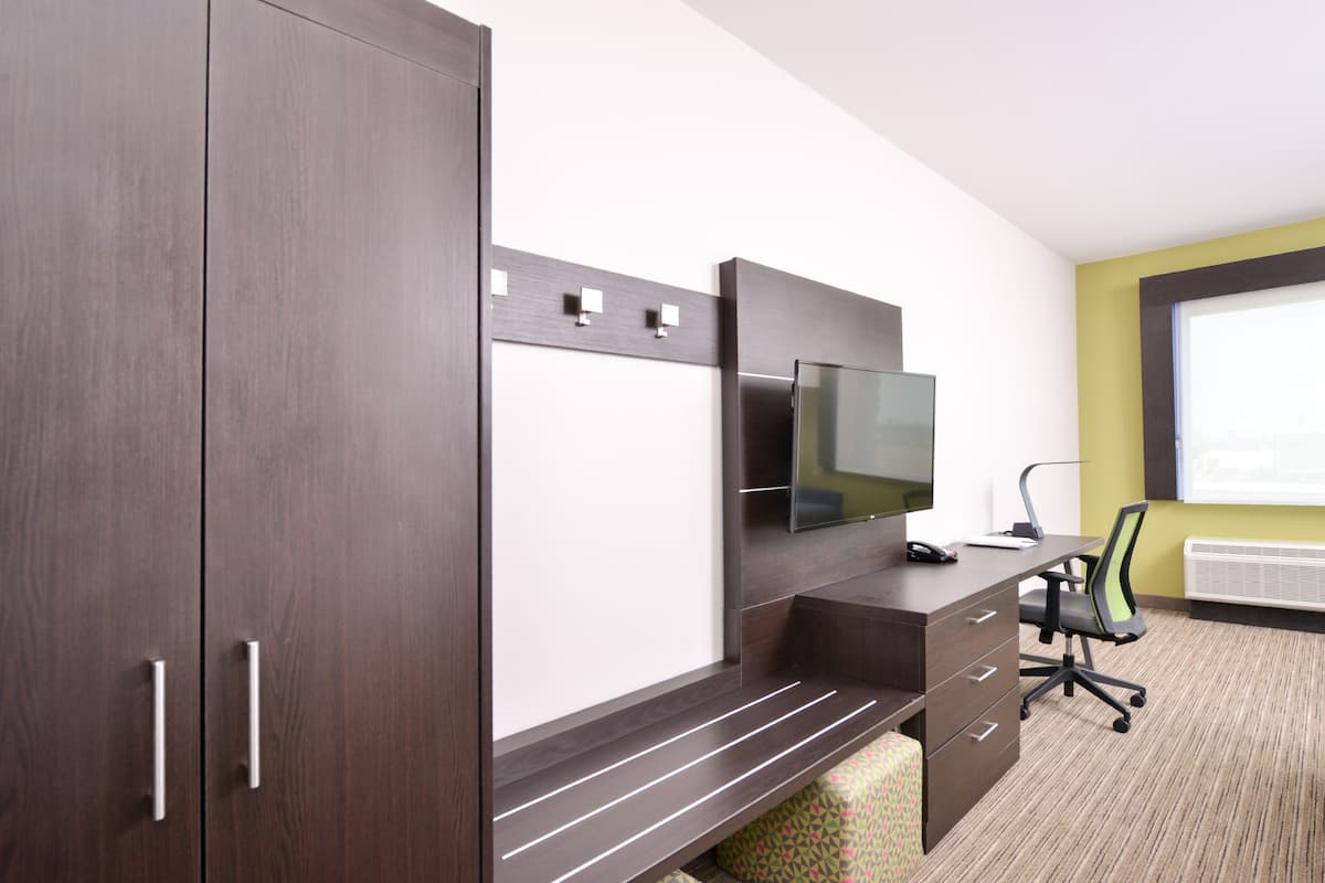 A modern office space with a desk, chair, and a large flat-screen TV.