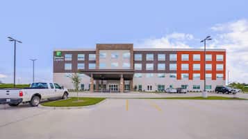 A Holiday Inn Express building with a parking lot, a white pickup truck, and a clear sky.