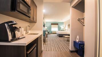 Una habitación de hotel con kitchenette, cama y baño.