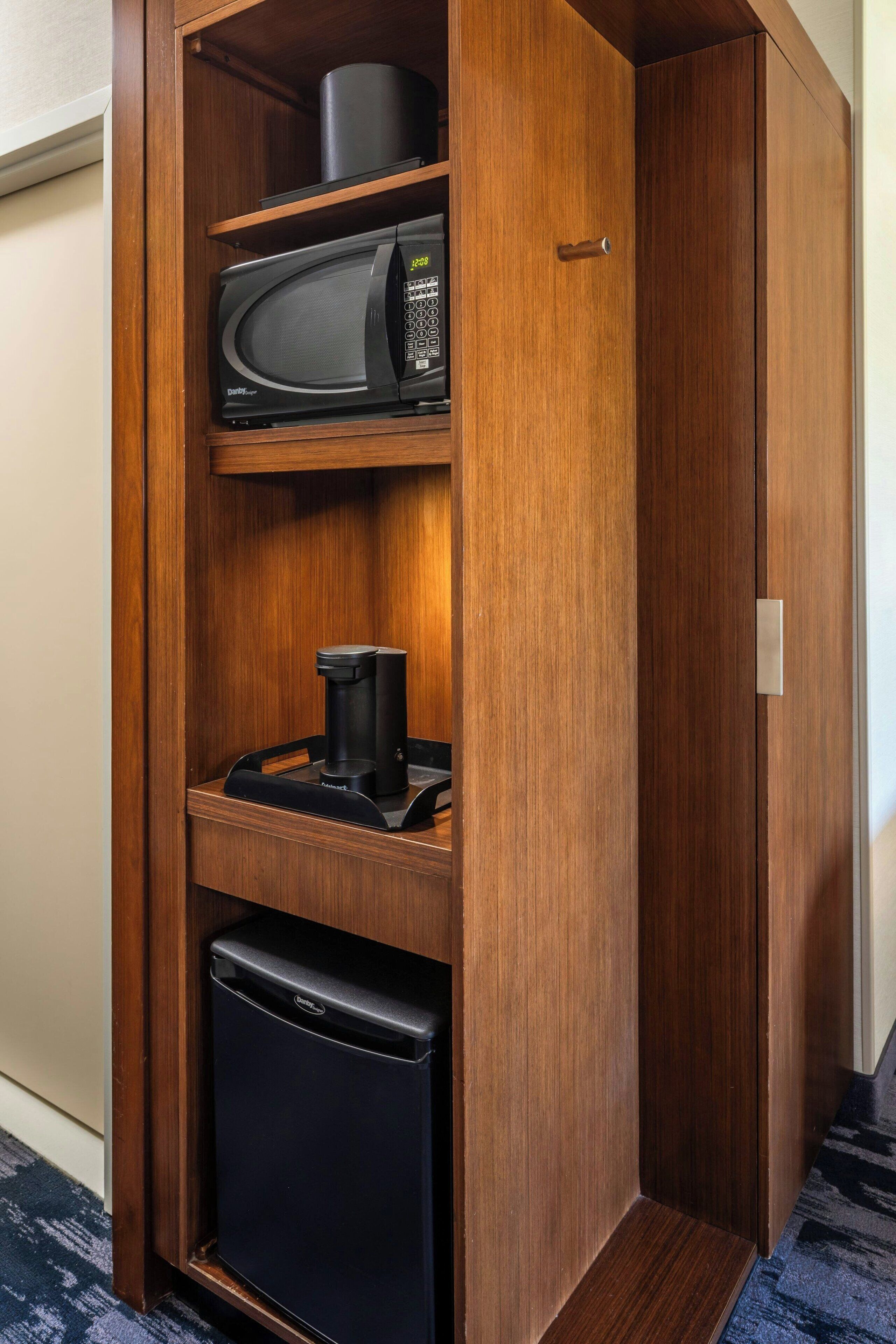 A compact kitchenette with a microwave, coffee maker, and mini-fridge.