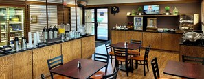 A restaurant with wooden paneling, a counter with coffee machines, and a TV displaying a movie.
