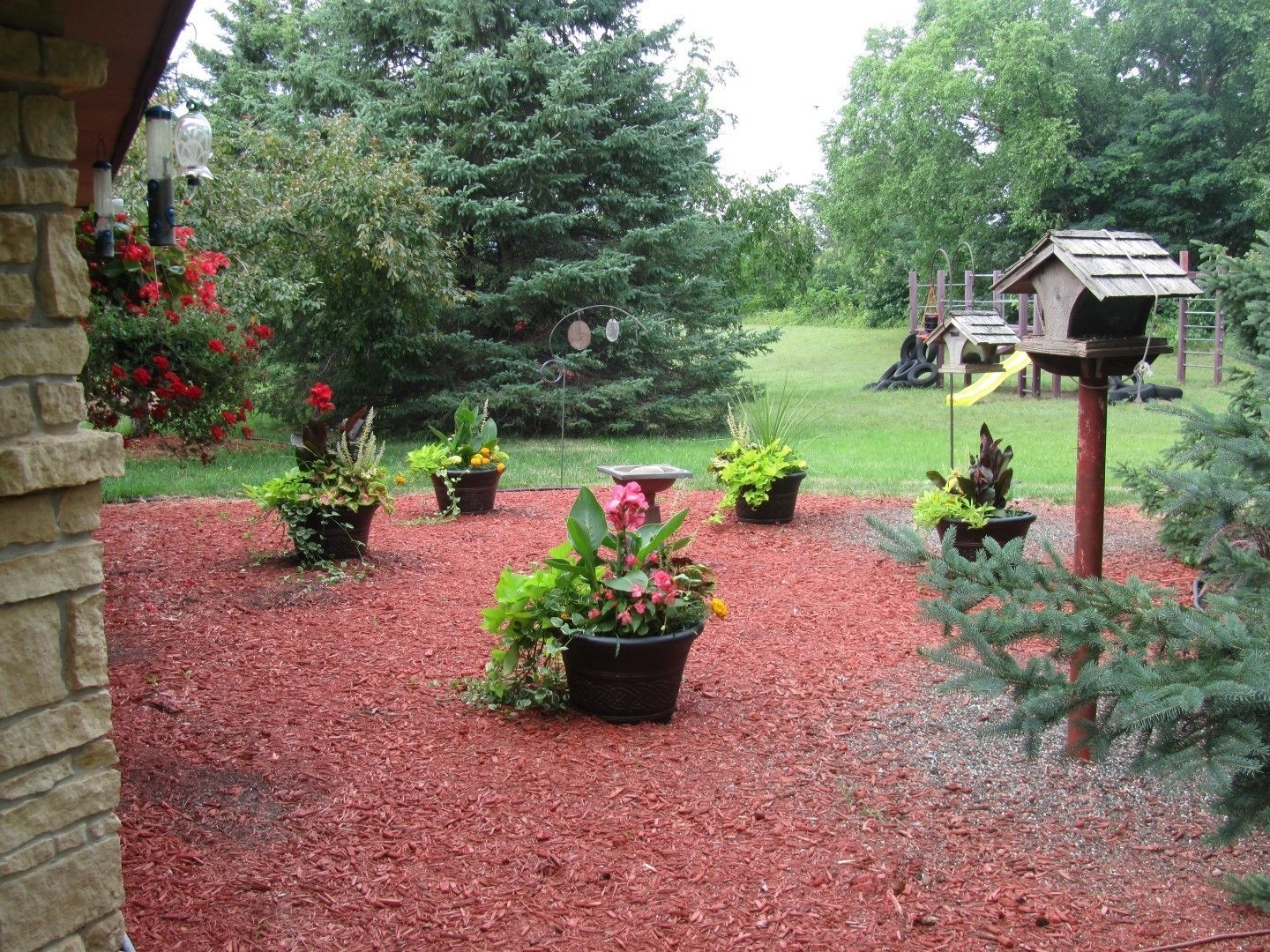 A garden with potted plants and a birdhouse.