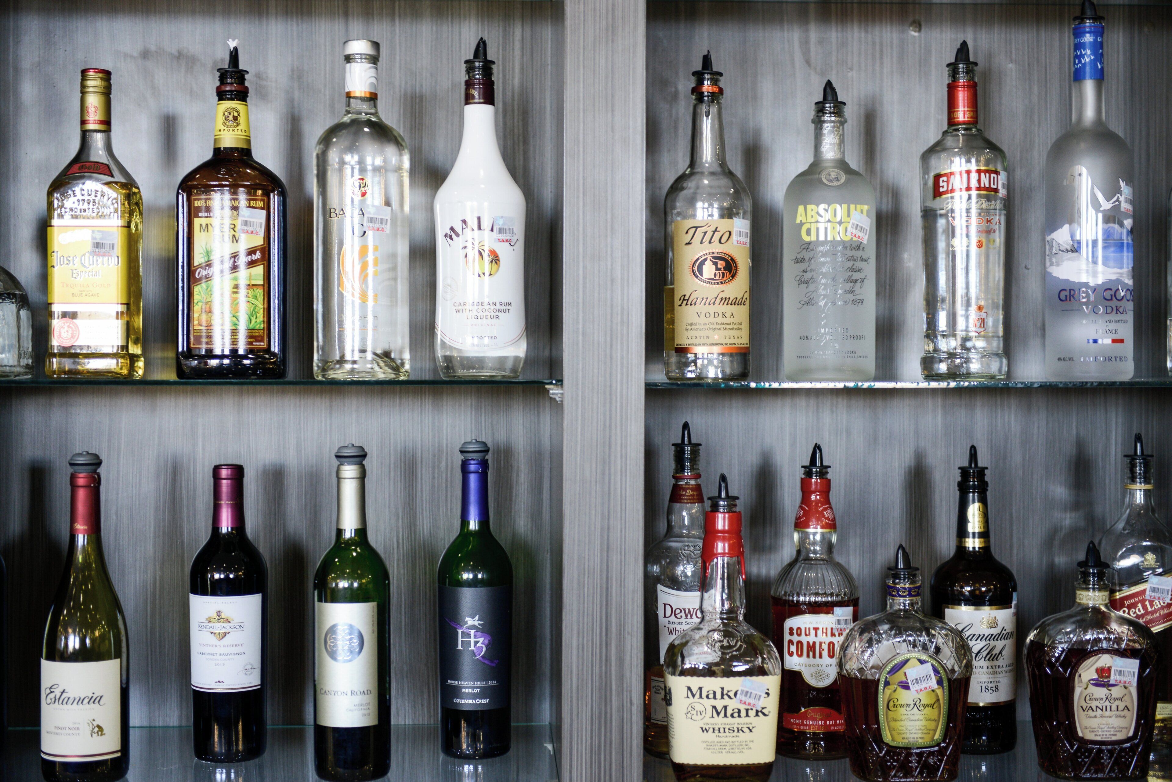 A variety of liquor bottles on shelves.