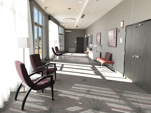 A modern waiting area with chairs, a bench, and artwork on the walls. - Holiday Inn Abilene - North College Area by IHG (Abilene)