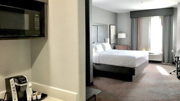 Une chambre d’hôtel équipée d’un lit, d’une table de chevet, d’une lampe et d’un four à micro-ondes.