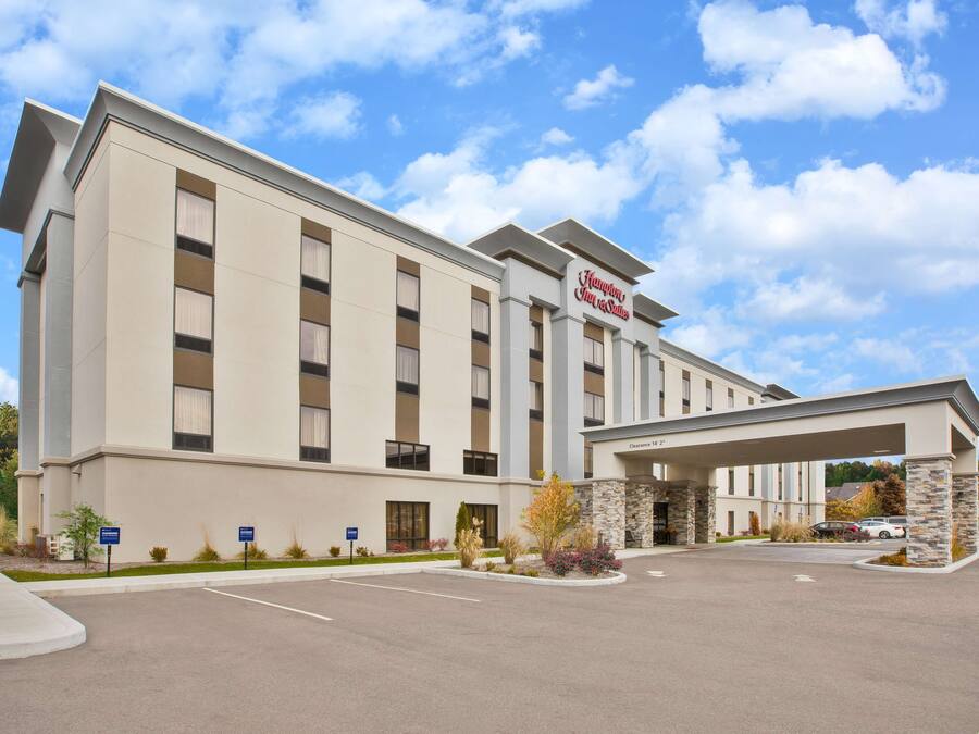 A modern hotel with a flat facade, a prominent sign, and a covered entrance.