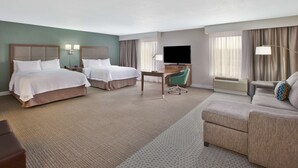 A hotel room with two beds, a desk, a TV, and a sofa. - Hampton Inn & Suites Alliance (Alliance)