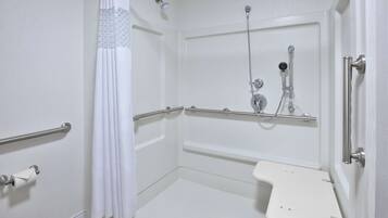 A wheelchair-accessible shower room with a white sink and grab bars.