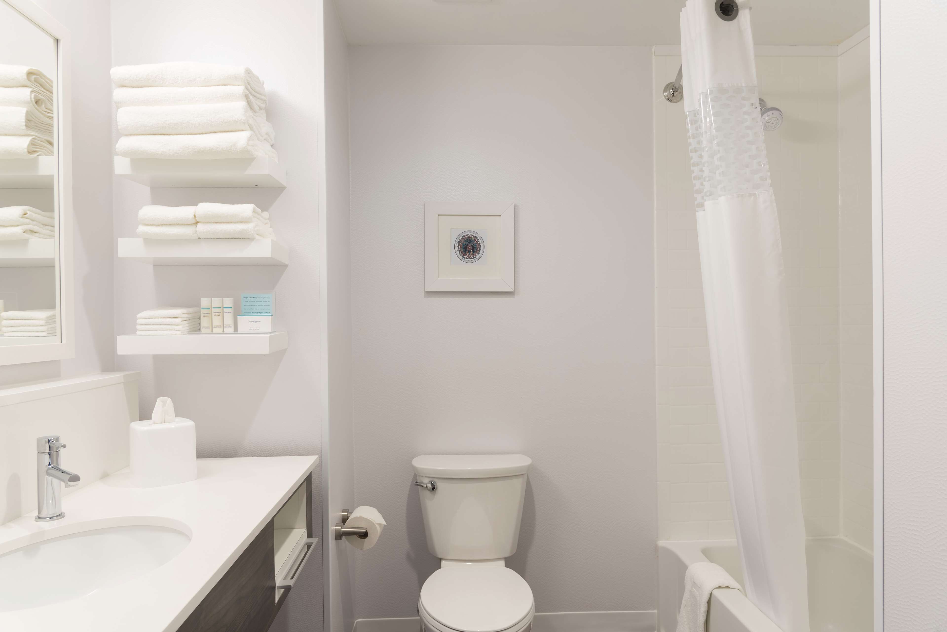 A bathroom with a toilet, sink, and shower curtain.