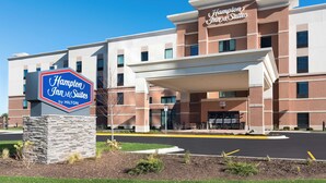 A Hampton Inn & Suites by Hilton building with a stone base sign, a covered entrance, and a brick facade. - Hampton Inn & Suites Chicago Schaumburg (Schaumburg)