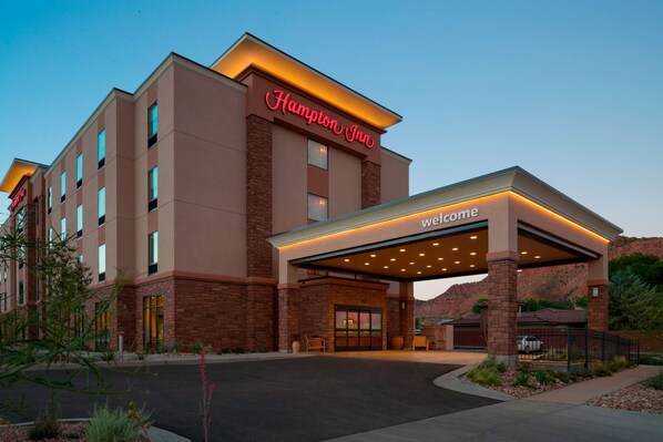 A Hampton Inn hotel with a prominent entrance and a covered walkway.