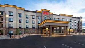 A modern hotel with a prominent entrance, multiple floors, and a welcoming sign.