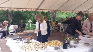 A covered outdoor event with buffet-style food service, guests seated at tables, and a band playing in the background. - The Governor's Inn (Rochester)
