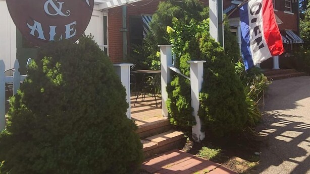 A building with a sign reading "Spaulding Steak & Ale" and a flag with "Oregon" on it. - The Governor's Inn (Rochester)
