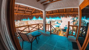 Uma área de estar coberta ao ar livre com vista para uma piscina e edifícios.