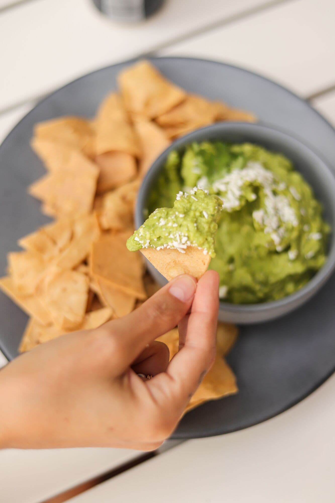 Eine Schüssel Guacamole mit einem Tortilla-Chip, der zum Dippen bereit ist.