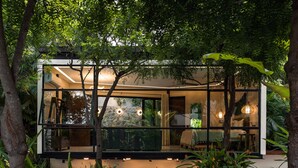 A modern glass house with a stone base, surrounded by lush greenery. - San Trópico Boutique Hotel & Peaceful Escape (Puerto Vallarta)