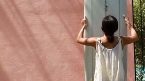 A person standing in front of a wall with a surfboard and the text "SAN TROPICAL". - San Trópico Boutique Hotel & Peaceful Escape (Puerto Vallarta)