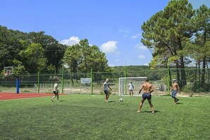 An outdoor sports field with a soccer goal, trees, and a clear sky. - Forest Beach (Primorsko)