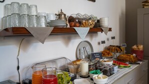 A buffet setup with various food items and beverages. - Hotel Mom Assisi (Assisi)