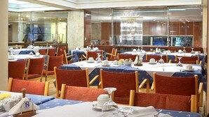 A conference room with multiple tables set for dining, equipped with chairs and table settings. - Samaras Hotel (Lamia)