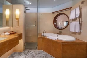 Un baño moderno con tocador doble lavabo, ducha a ras de suelo y un espejo grande.