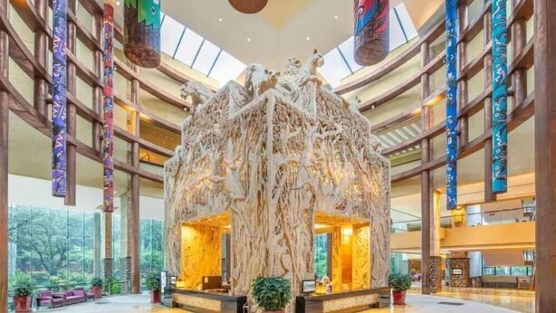 A spacious lobby with a central sculpture, high ceilings, and large windows. - Chimelong Hotel (Guangzhou)