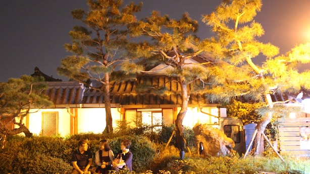 A traditional building with a tiled roof and a well-maintained garden with pine trees. - Sungsim (Jeonju)