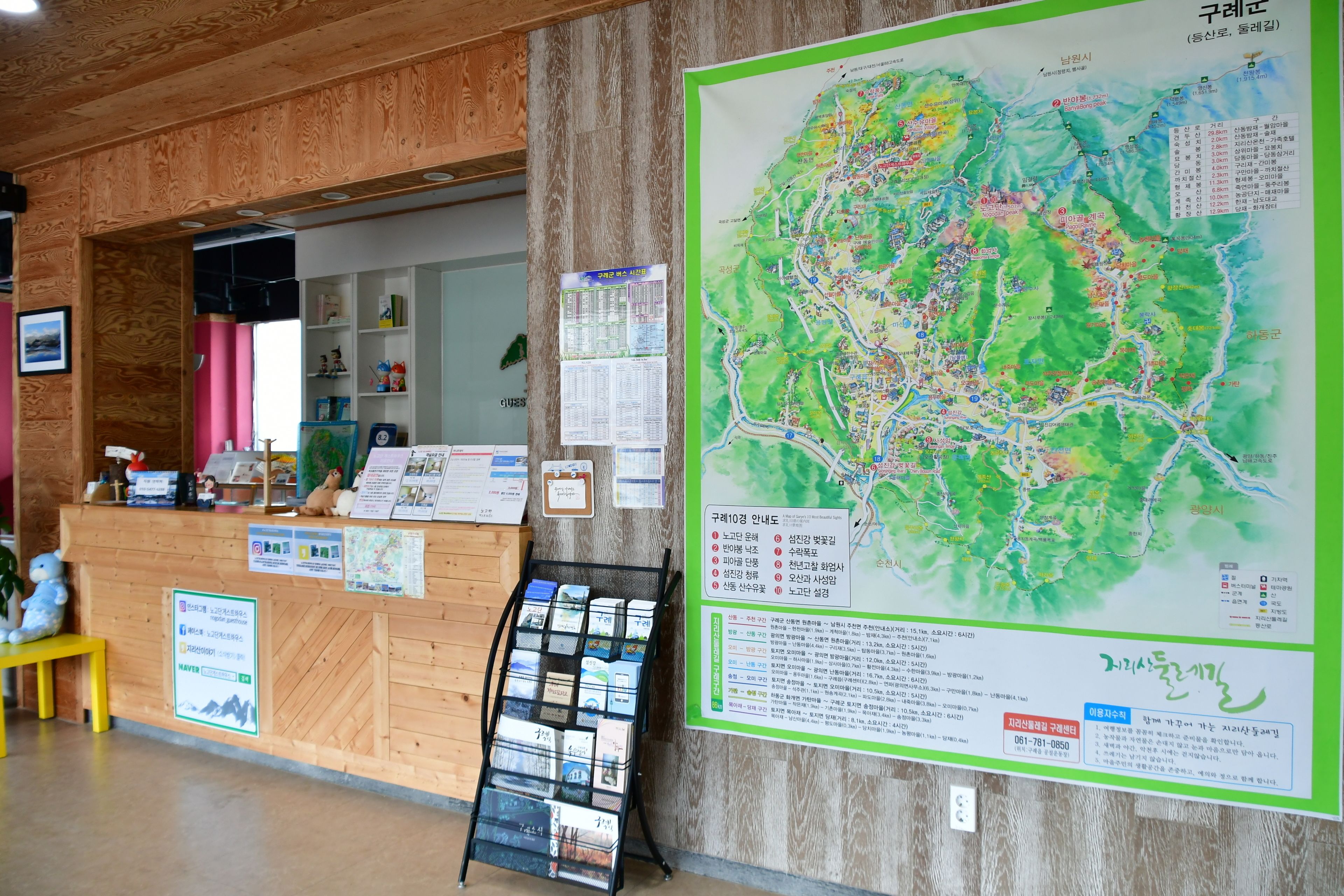 A reception area with a wooden reception desk, a map, and informational posters.