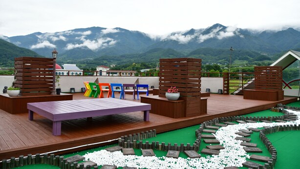 Una terraza con mobiliario y vistas a las montañas.