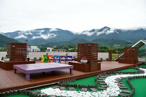 Una terraza con mobiliario y vistas a las montañas.