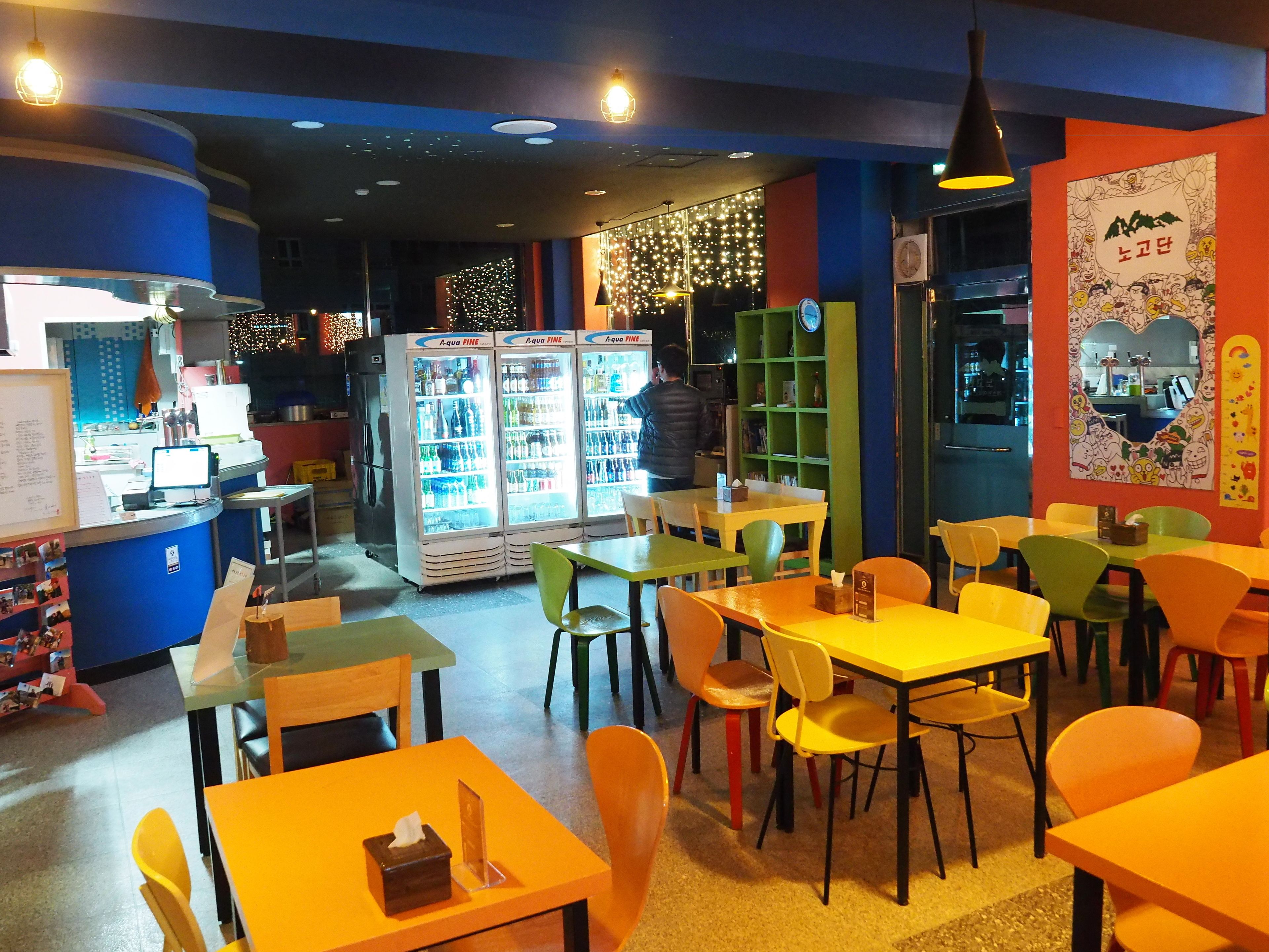 Interior de restaurant amb taules, cadires i una barra.