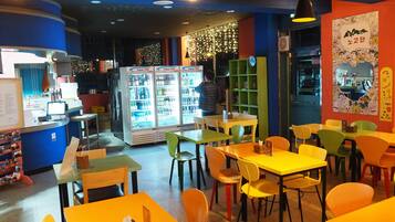 Interior de restaurant amb taules, cadires i una barra.
