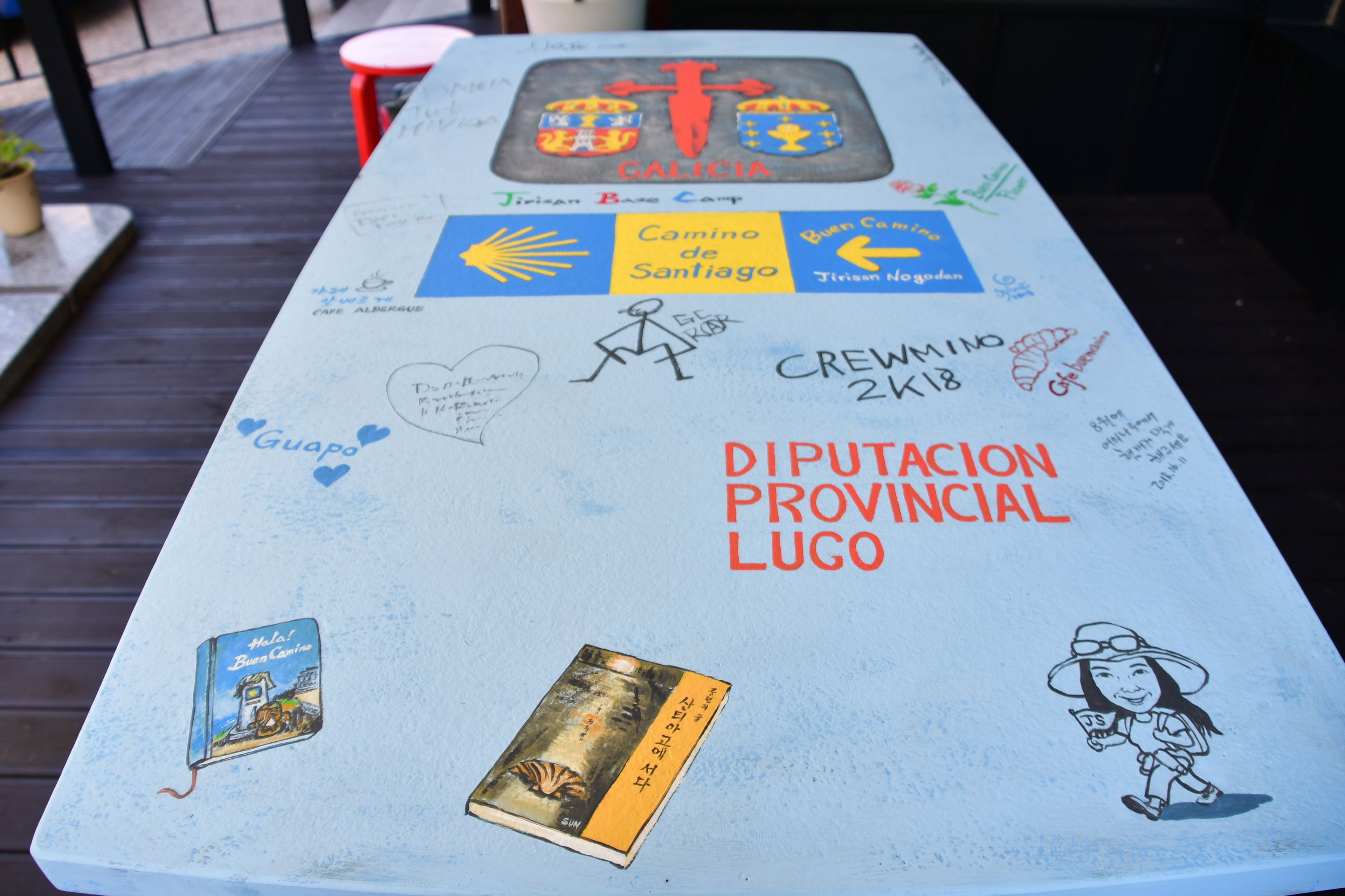 A table with various stickers and drawings, including a map, a sun, and a character illustration.