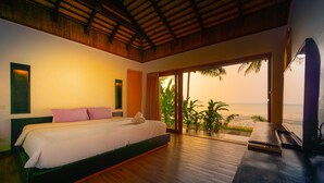 Une chambre avec un lit, un bureau et une vue sur la plage.