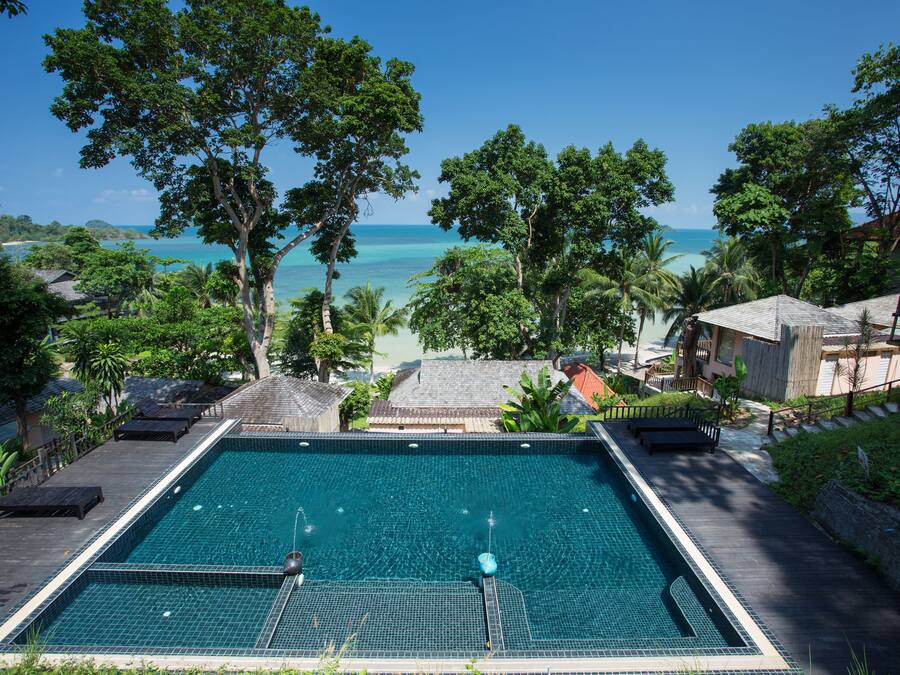 Una piscina rectangular con vista a la playa y al océano.